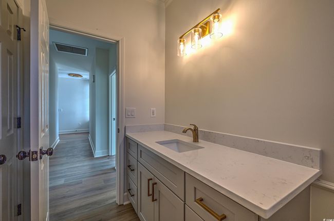 Bathroom featuring wood finished floors, vanity, and ornamental molding | Image 17