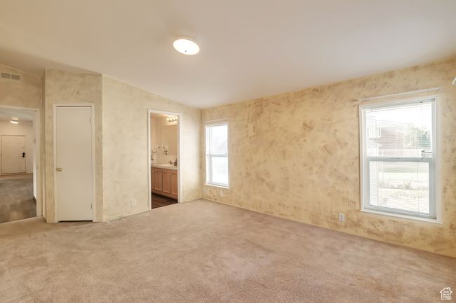 Unfurnished bedroom featuring carpet floors, ensuite bathroom, and vaulted ceiling | Image 12