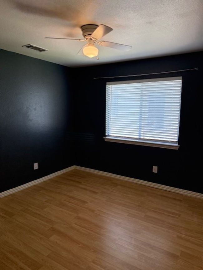 Empty room featuring wood finished floors, a textured ceiling, and a ceiling fan | Image 17