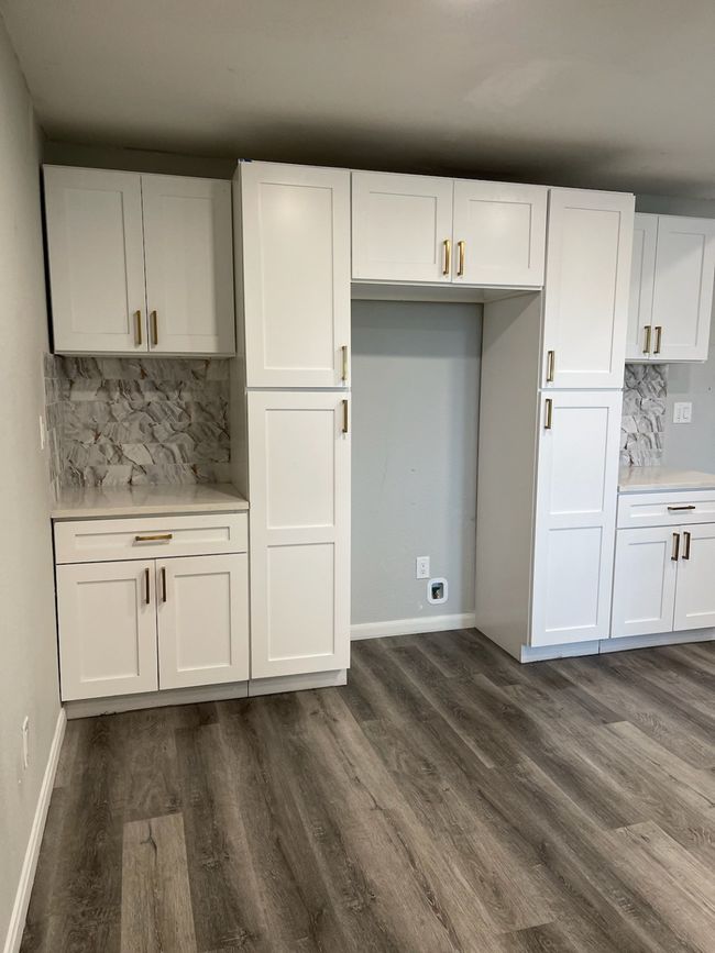 Kitchen featuring white cabinetry and tasteful backsplash | Image 11