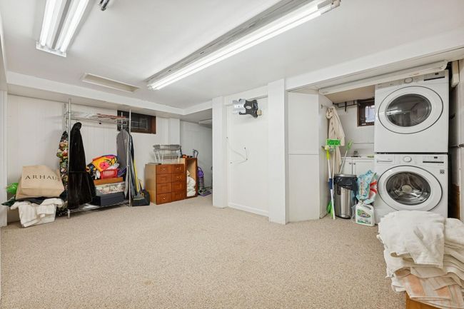 Finished below grade area featuring stacked washer and clothes dryer and carpet floors | Image 21