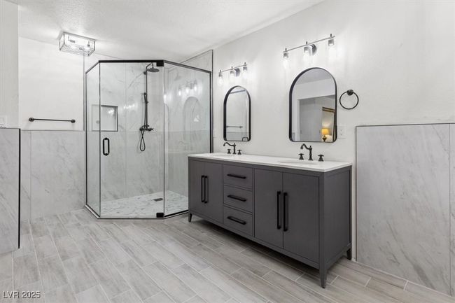 Bathroom featuring a marble finish shower, double vanity, and a sink | Image 18