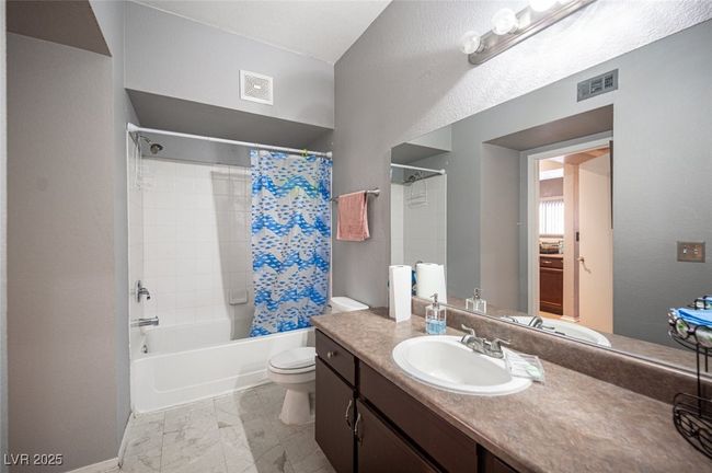 Bathroom with toilet, shower / bath combo, vanity, and visible vents | Image 28