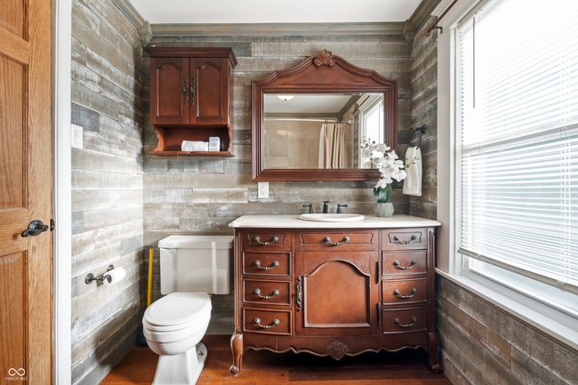 bathroom with healthy amount of natural light, vanity, dark wood-type flooring, wooden walls, and a shower with curtain | Image 37