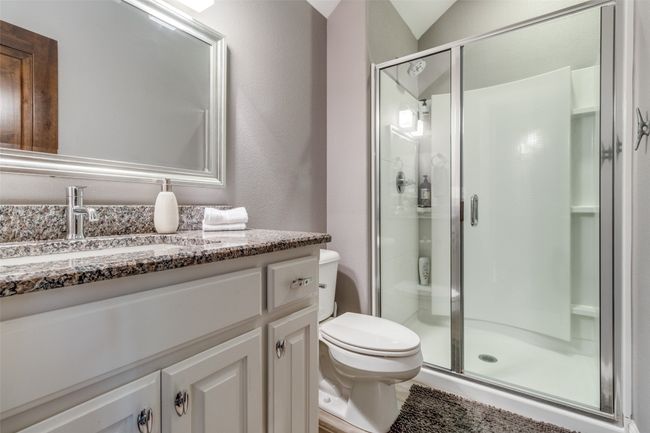 Bathroom with a shower with shower door, toilet, and vanity | Image 24