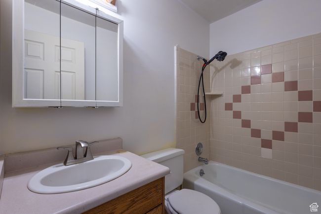 Full bathroom featuring toilet, vanity, and shower combination | Image 14