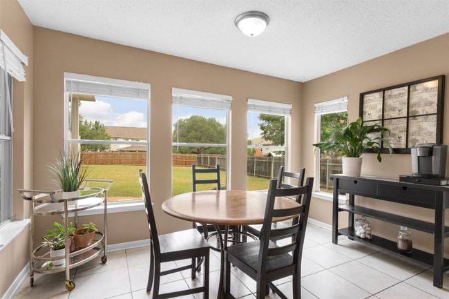 Bright and inviting dining area, abundant with natural light, featuring elegant baseboards and a stylish tiled floor, perfect for entertaining or enjoying family meals. | Image 18