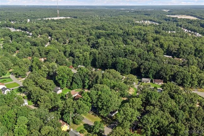 Aerial view of property and surrounding area with a heavily wooded area | Image 44