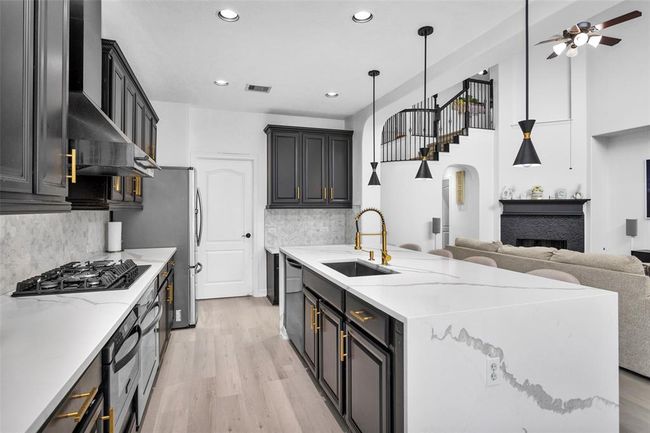 The quartz countertops and gold accents bring the custom details into the kitchen. | Image 16