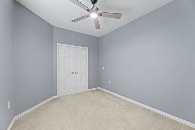 Unfurnished bedroom featuring light carpet, a closet, and a ceiling fan | Image 11