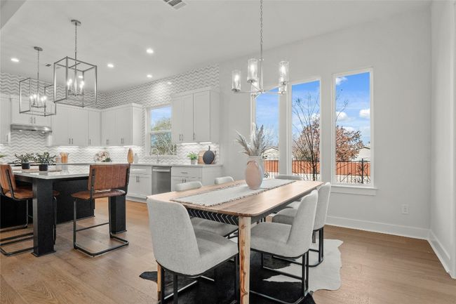 Dining space with baseboards, a notable chandelier, light wood finished floors, and recessed lighting | Image 8