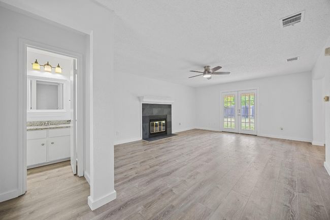 Unfurnished living room featuring ceiling fan, a textured ceiling, visible vents, and light wood-style flooring | Image 8