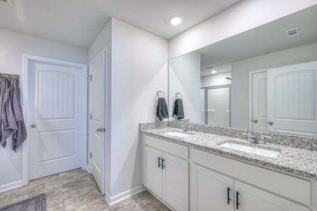 Primary Bathroom has double vanities, Water Closet, oversized Linen Closet, 10'x7' walk-in Closet & enclosed shower. | Image 16