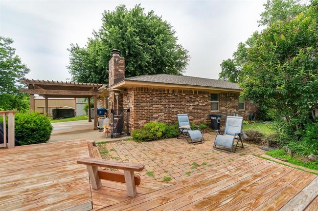 Wooden deck with a pergola and a patio | Image 38