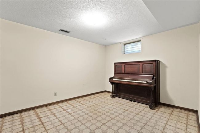 Sitting room featuring light floors, baseboards, and a textured ceiling | Image 21
