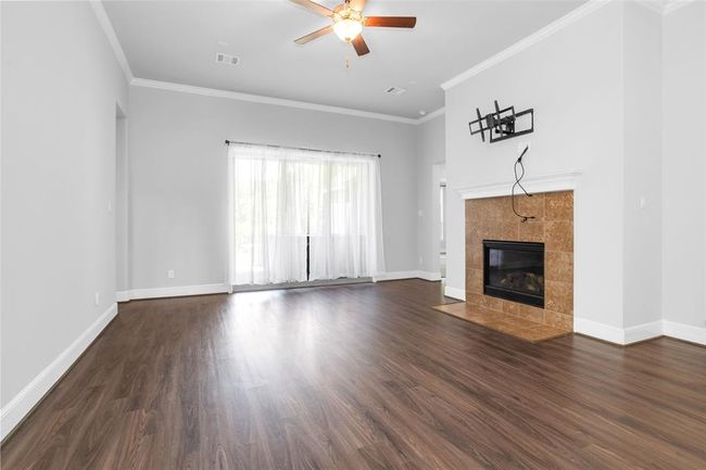Spacious living room with a cozy gas fireplace and French doors leading to a patio featuring a jacuzzi and fire pit. | Image 11