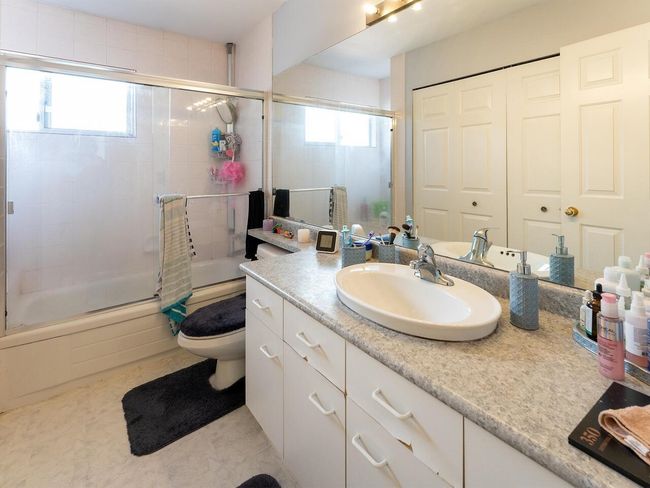 Bathroom featuring bath / shower combo with glass door, toilet, and vanity | Image 23