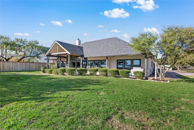 Rear view of property featuring a shingled roof and a chimney | Image 9
