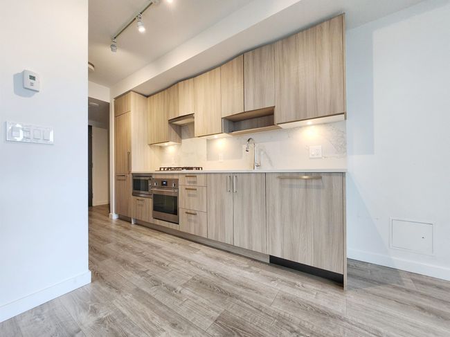 Kitchen with light brown cabinetry, wall oven, modern cabinets, and track lighting | Image 6
