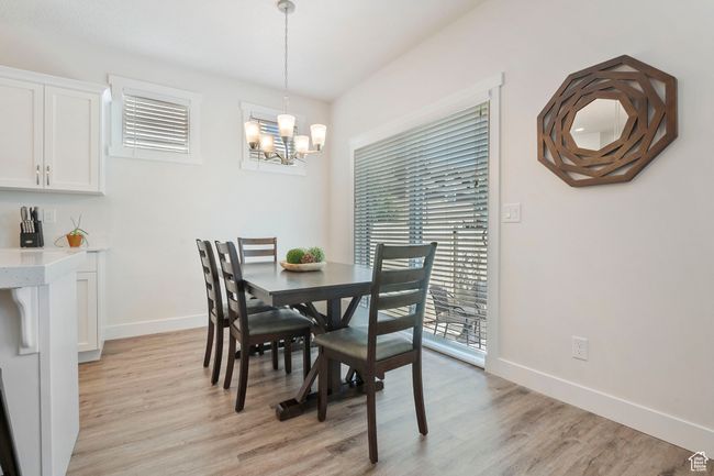 Dining space featuring light wood-style floors and a chandelier | Image 8