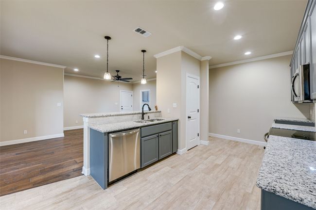 Kitchen featuring appliances with stainless steel finishes, ceiling fan, a sink, recessed lighting, and crown molding | Image 7