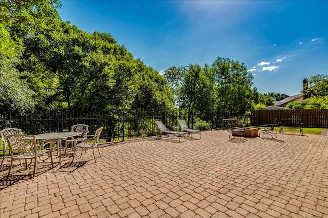 Sprawling back patio overlooks greenbelt backyard setting and offers the perfect area for relaxation or entertaining! | Image 31