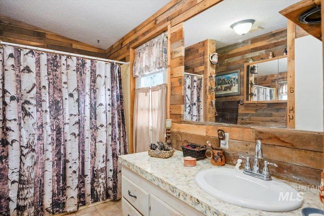 Bathroom featuring wood walls, vanity, a textured ceiling, and a shower with shower curtain | Image 20