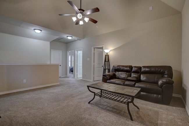 Living room featuring light colored carpet, ceiling fan, and vaulted ceiling | Image 28