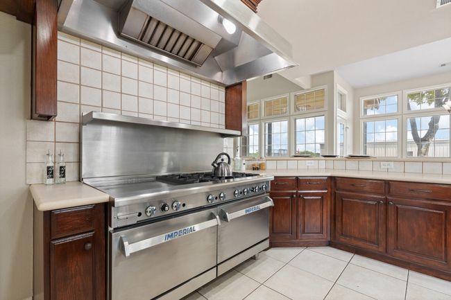 Can you imagine preparing meals on this Imperial 6 gas burner range, 24in griddle and two 36in ovens, large enough to fit a full size baking sheet? More cabinets for storage and looking at the high top counter with seating on the back side for at least 4-6. Loaded wtih natural light. | Image 18
