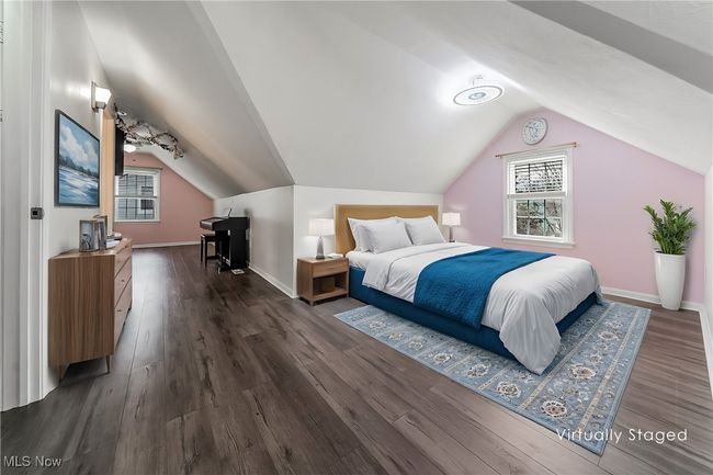 Bedroom featuring dark wood finished floors, baseboards, and lofted ceiling | Image 24