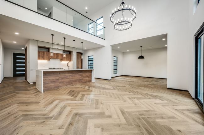 Unfurnished living room with a towering ceiling and a chandelier | Image 9