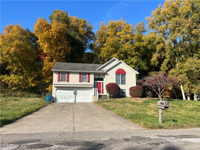 Bi-level home featuring a front lawn and a garage | Image 2