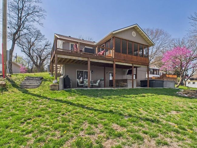 Back of property with a patio, a wooden deck, a sunroom, and a lawn | Image 7
