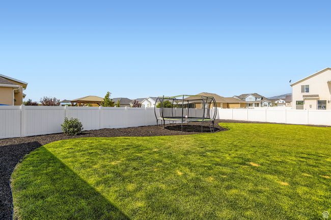 Fenced backyard with a trampoline and a residential view | Image 20