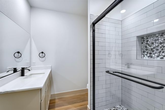 Bathroom with a shower stall, vanity, baseboards, and wood finished floors | Image 9
