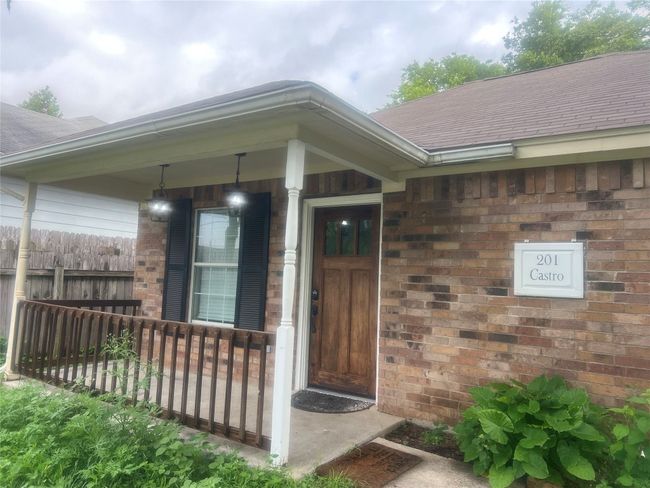 Property entrance with roof with shingles, covered porch, and brick siding | Image 17