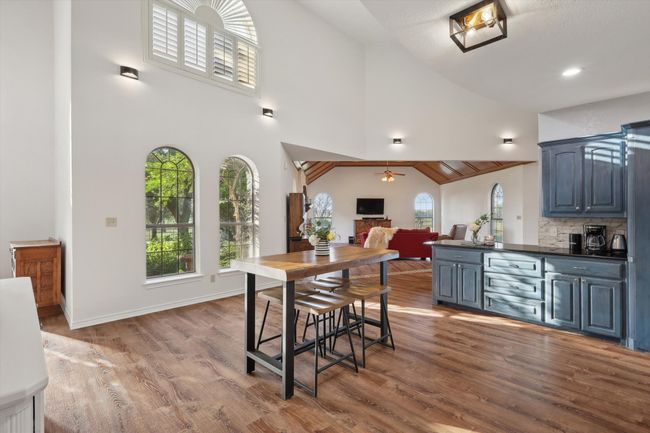 Dining room with plenty of natural light, wood finished floors, a ceiling fan, and high vaulted ceiling | Image 15