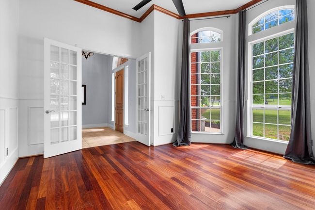 Bright and inspiring home office featuring beautiful wood flooring and expansive windows that flood the space with natural light! | Image 4