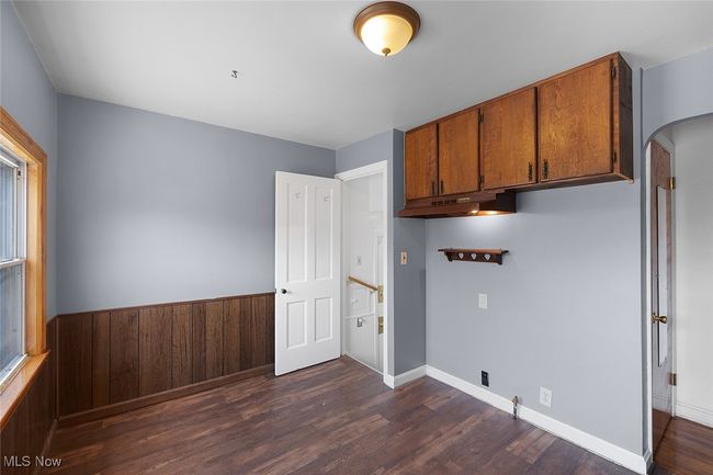 kitchen room with dark wood-style floors, arched walkways, and cabinet space | Image 6