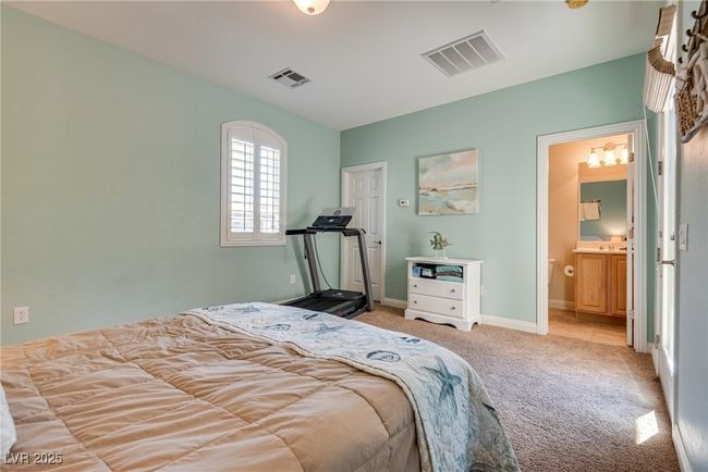 Carpeted bedroom featuring ensuite bath, baseboards, and visible vents | Image 60