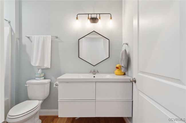 Bathroom featuring toilet, vanity, baseboards, and wood finished floors | Image 31