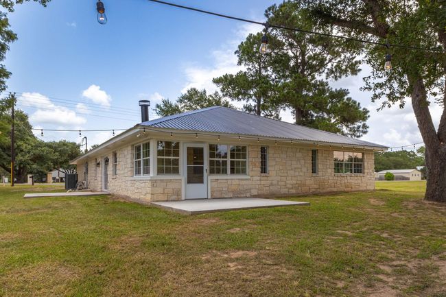Charming stone exterior with a spacious backyard, perfect for outdoor gatherings. | Image 36