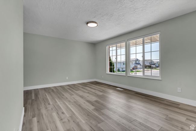 Unfurnished room featuring a textured ceiling, wood finished floors, and baseboards | Image 7
