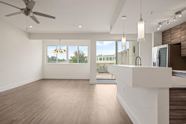 Unfurnished living room with light wood-style floors, a chandelier, ceiling fan, and recessed lighting | Image 10