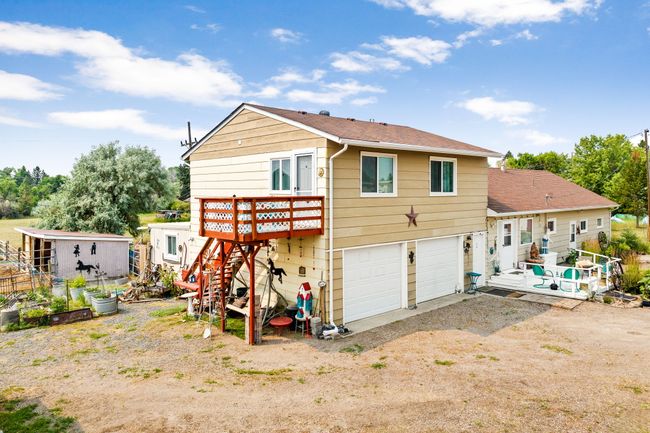 Back of house featuring stairway, a wooden deck, driveway, a garage, and a shingled roof | Image 10