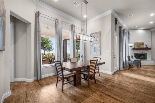 Dining area featuring crown molding, 12-foot ceilings, drapes & chandelier. | Image 11