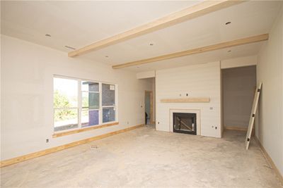 The centerpiece of the living area is a cozy fireplace framed by shiplap surround and a wood mantel, while ample windows flood the space with natural light. | Image 3