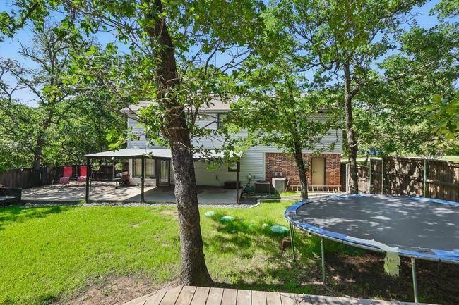 Fenced backyard with a trampoline and a patio | Image 34