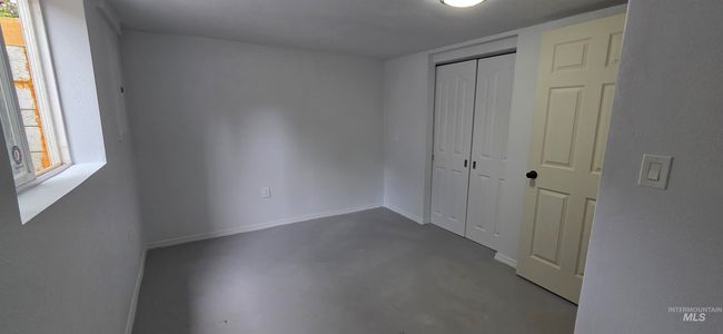 Unfurnished bedroom featuring finished concrete flooring and a closet | Image 18