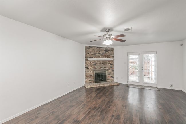 Living room with laminate wood flooring & ceili g fan. | Image 5